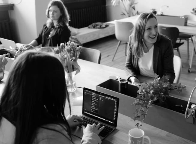 Several business women inside an office working.